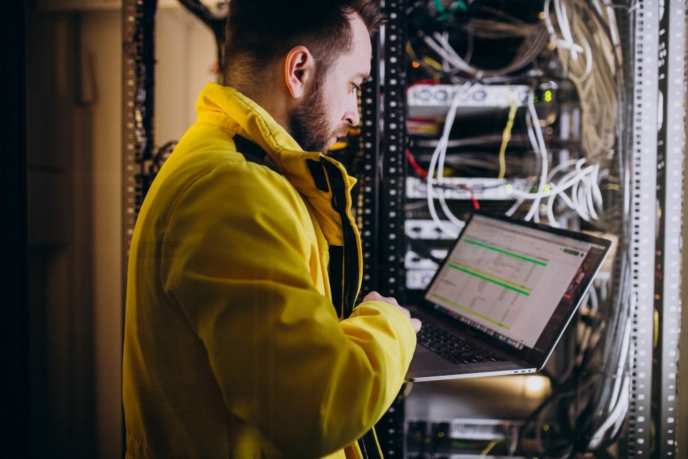 Estudante verifica conexões de rede em data center durante estágio engenharia da computação