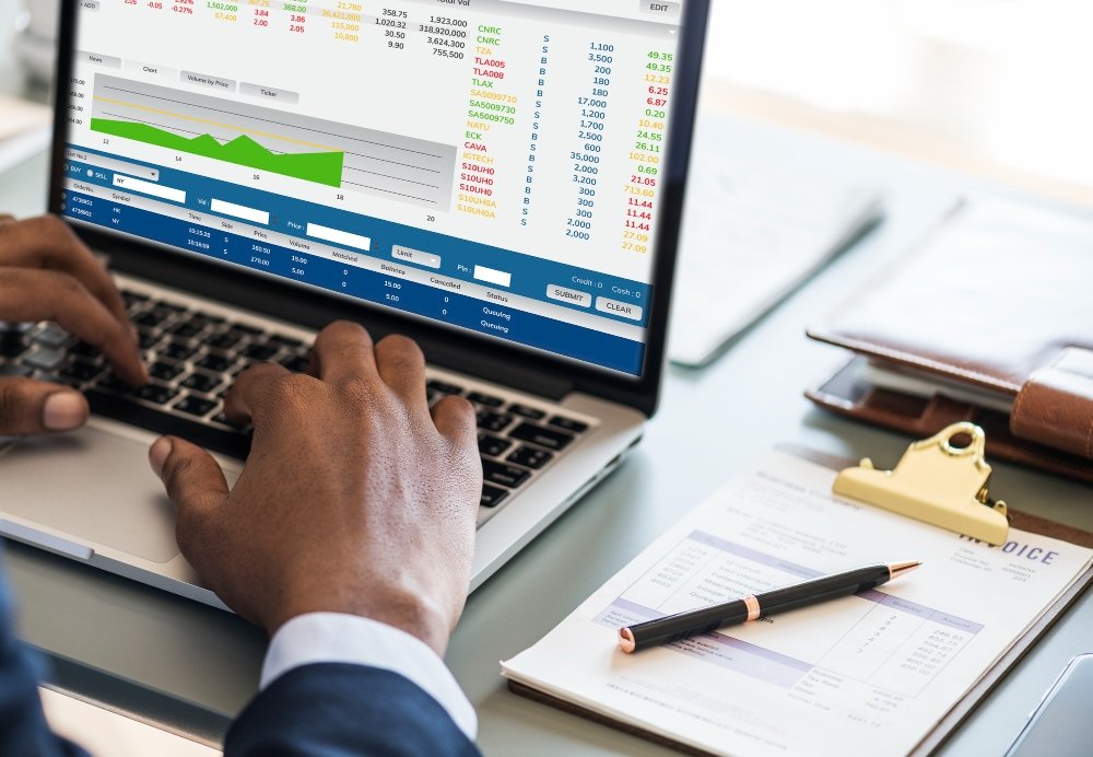 Estagiário analisando dados financeiros em planilhas durante estágio financeiro em escritório corporativo.